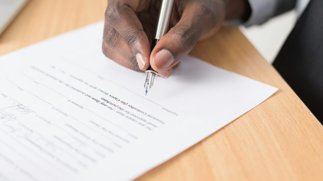 Hand unterschreibt ein Dokument