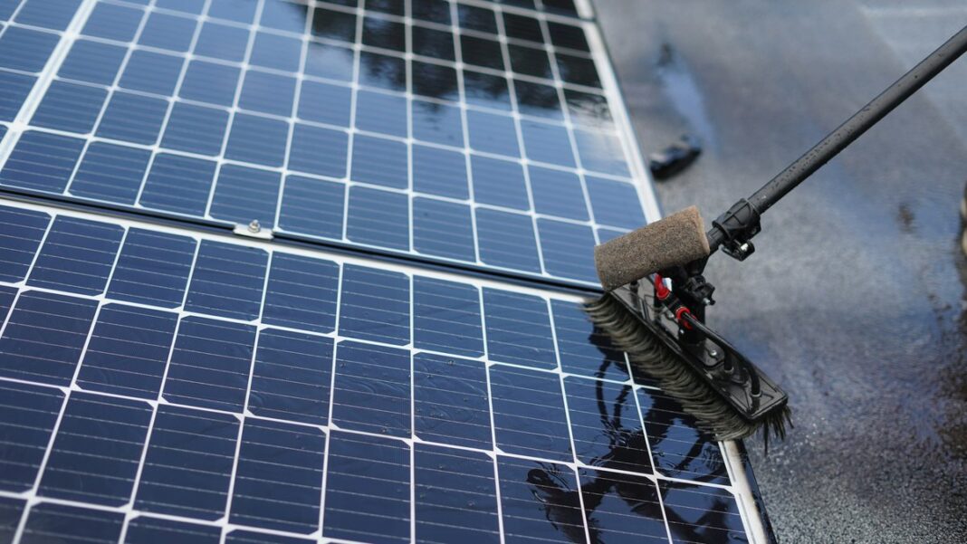 PV-Module werden mit einer weichen Bürste an einer Teleskopstange gereinigt